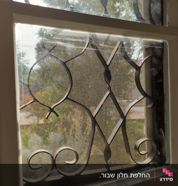 חלון זכוכית עם סורגי מתכת מעוצבים